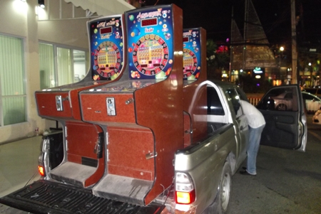 Police load up the confiscated slot machines to truck them away.
